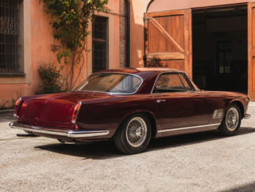 Maserati classique bordeaux dans une cour historique de Modène avant restauration