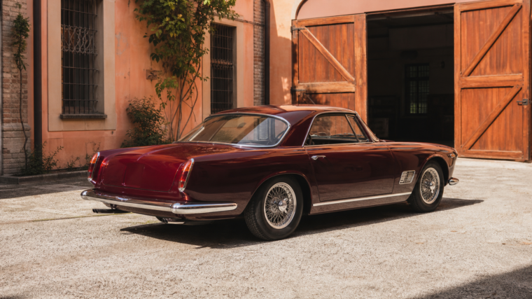 Maserati classique bordeaux dans une cour historique de Modène avant restauration