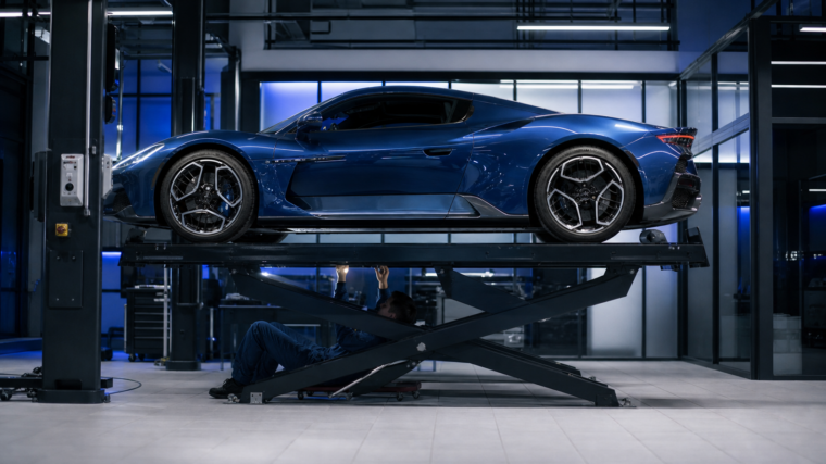 Maserati MC20 bleue inspectée sur un pont dans un centre automobile spécialisé