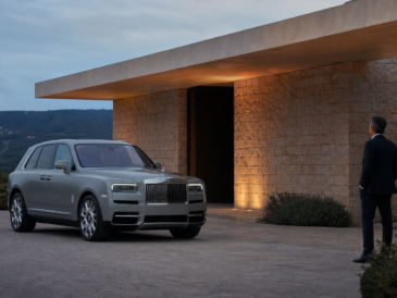 Rolls-Royce Cullinan gris argent devant une architecture contemporaine au crépuscule