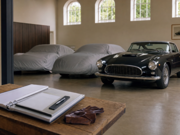 Garage privé avec voitures de collection et dossier d'inventaire posé sur un établi