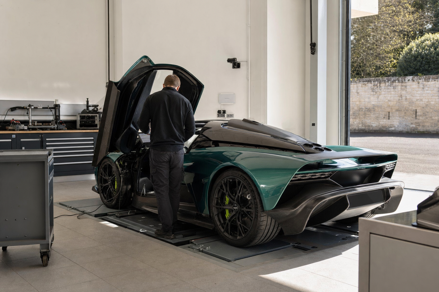 Technicien réalisant un diagnostic sur une supercar hybride verte dans un atelier lumineux
