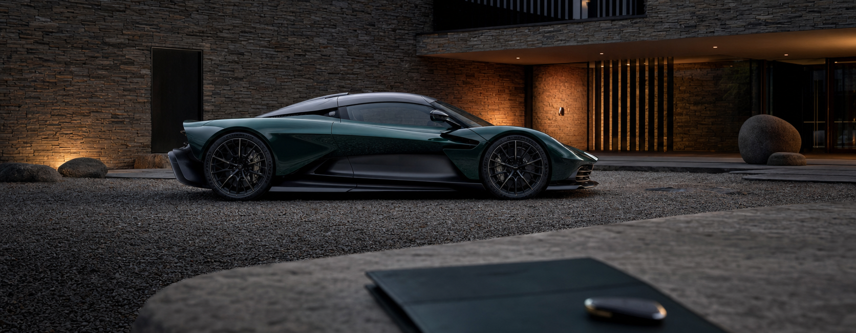 Aston Martin Valhalla verte devant une architecture contemporaine avec dossier de livraison au premier plan