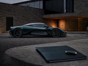 Aston Martin Valhalla verte devant une architecture contemporaine avec dossier de livraison au premier plan