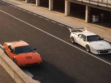 BMW M1 routière orange et BMW M1 Procar blanche dans les stands d’un circuit historique