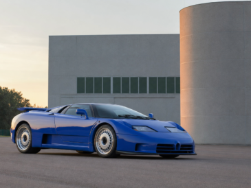 Hypercar bleue des années 1990 devant une architecture industrielle italienne au lever du jour