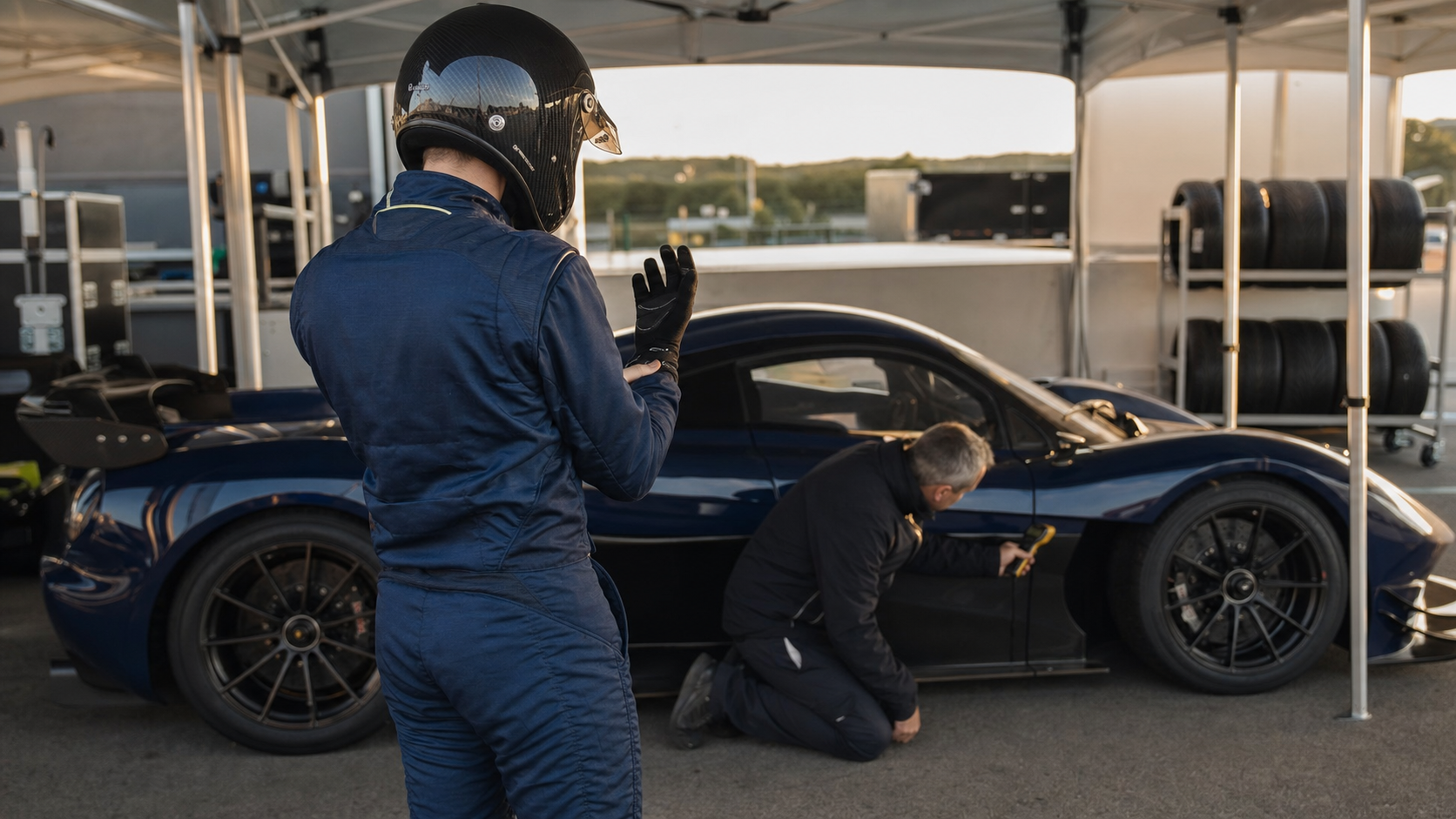 Pilote et ingénieur préparant une hypercar bleue pour une séance privée sur circuit