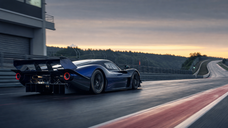 Hypercar de piste bleu nuit accélérant à la sortie des stands au lever du jour