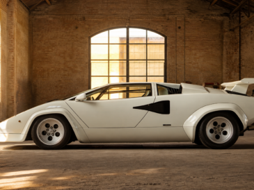 Lamborghini Countach blanche de profil dans un hangar italien en briques avant restauration
