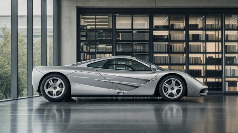 McLaren F1 argentée présentée dans une salle d’archives automobile contemporaine