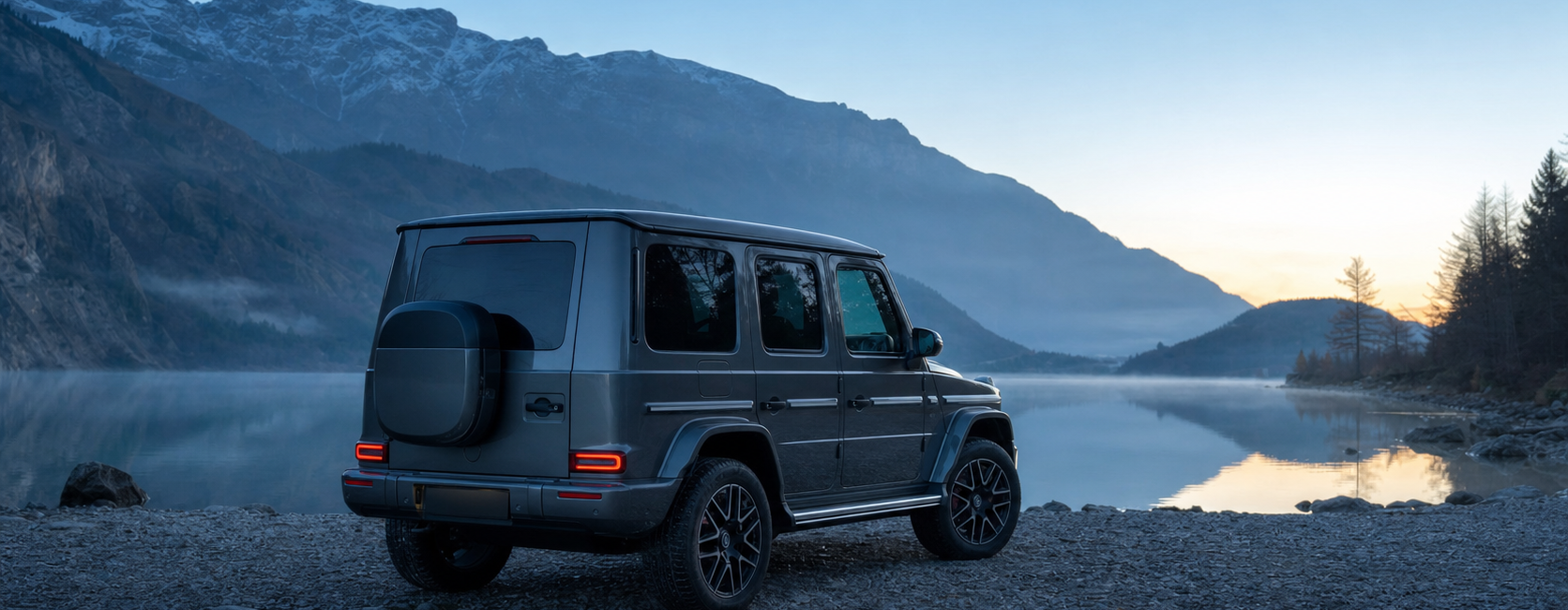 Mercedes G 580 électrique gris graphite au bord d'un lac alpin au lever du jour