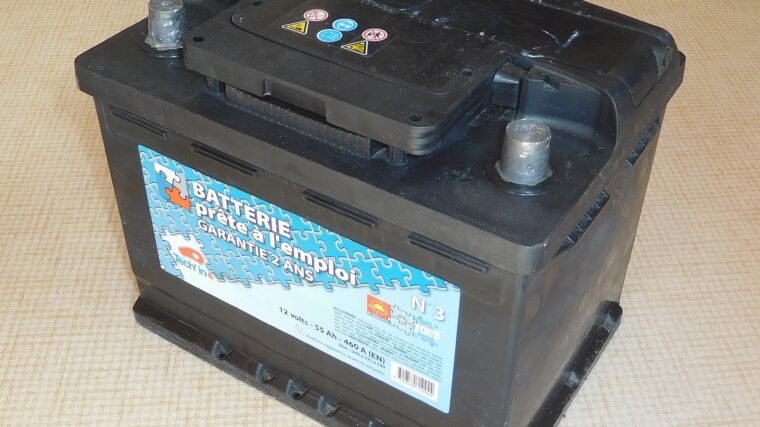 Batterie automobile noire au plomb portant les indications 12 volts et 55 ampères-heures