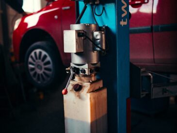 Voiture ancienne installée sur un pont élévateur dans un atelier de contrôle
