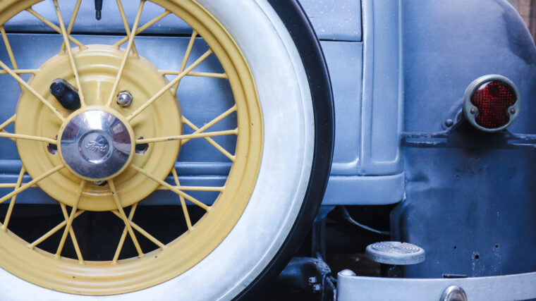 Roue à rayons et pneu à flanc blanc d’une voiture ancienne