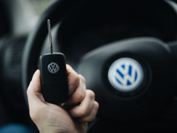 Main tenant une clé de voiture devant le volant
