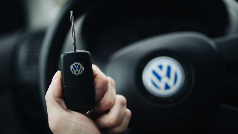 Main tenant une clé de voiture devant le volant