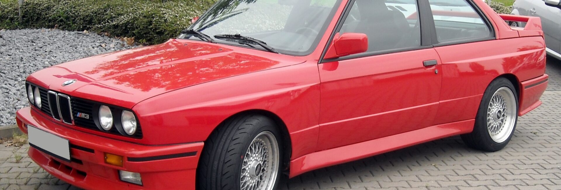 BMW M3 E30 rouge vue de trois quarts avant