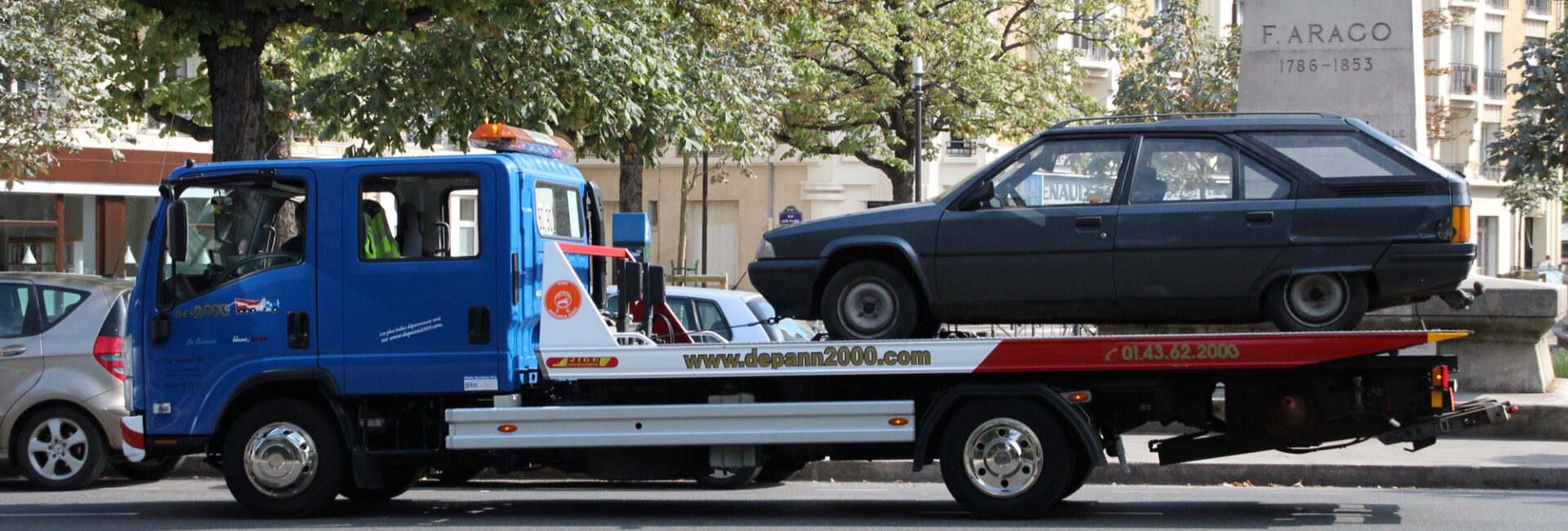 Voiture ancienne chargée sur le plateau d’une dépanneuse