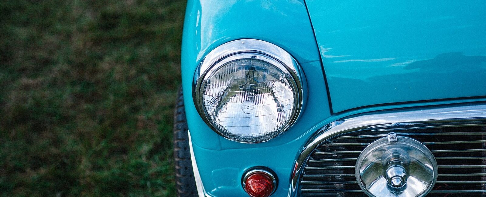 Phare et calandre chromée d’une voiture ancienne turquoise