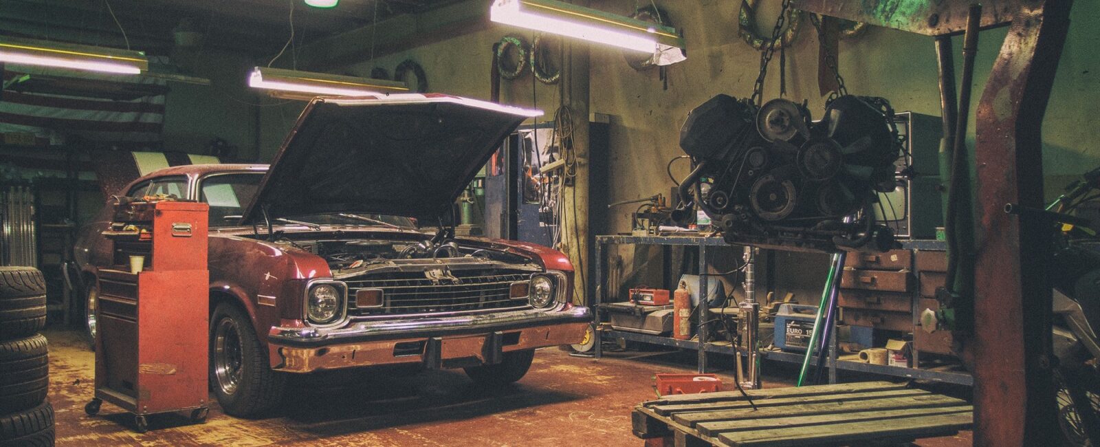 Voiture ancienne dans un atelier avec un moteur déposé avant transformation