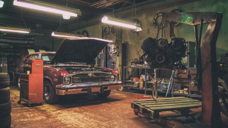 Voiture ancienne dans un atelier avec un moteur déposé avant transformation