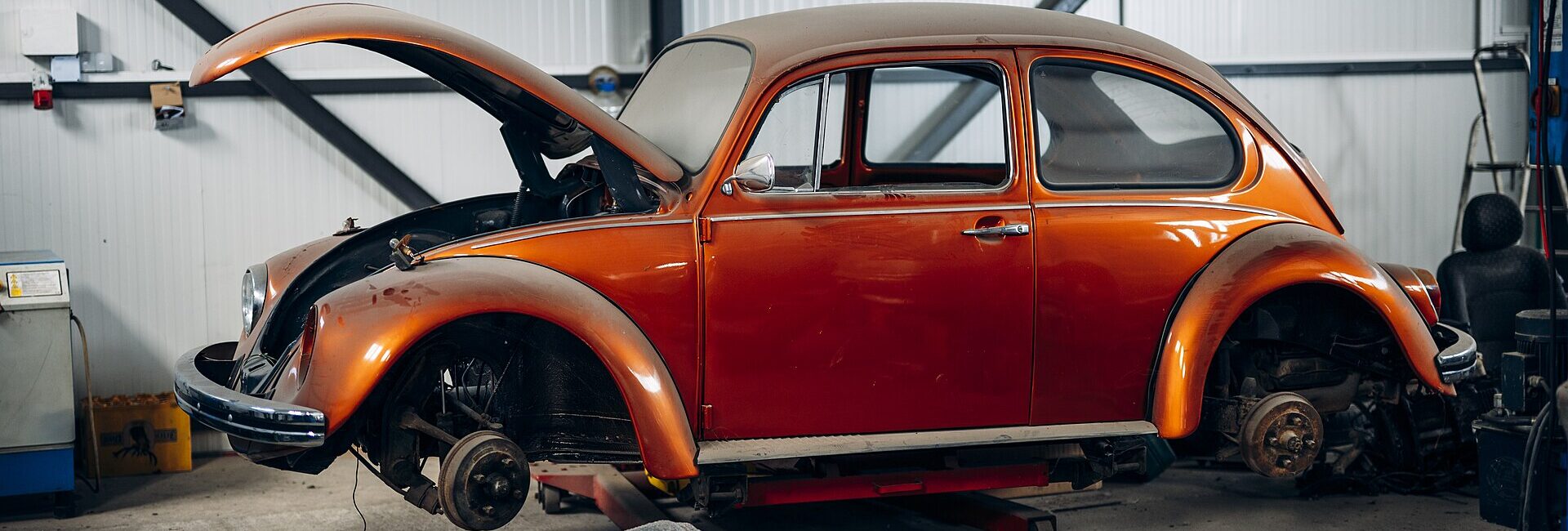 Volkswagen Coccinelle ancienne inspectée sur un pont dans un garage