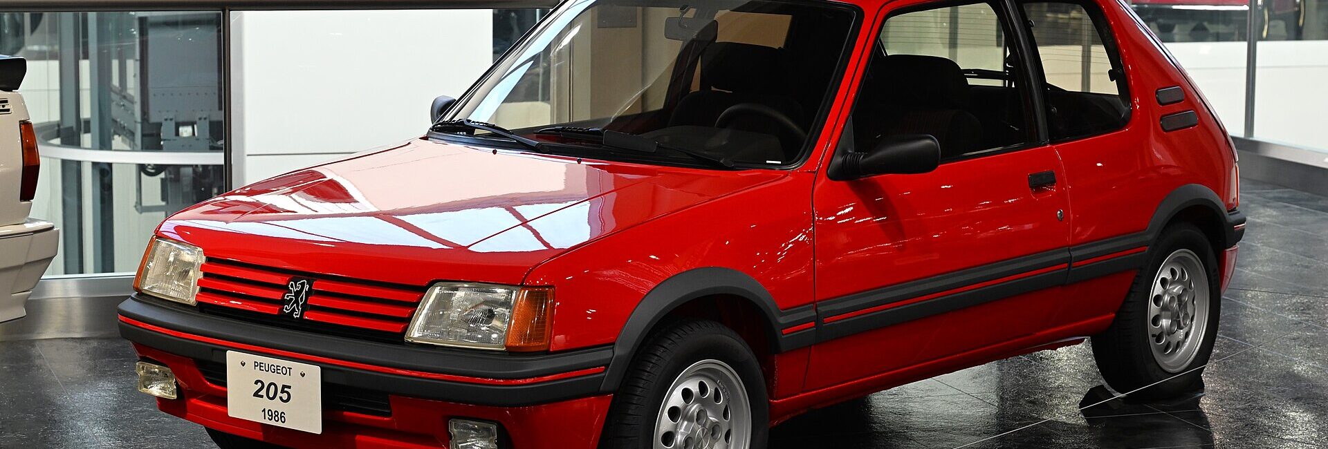 Peugeot 205 GTI rouge de 1986 exposée de trois quarts avant