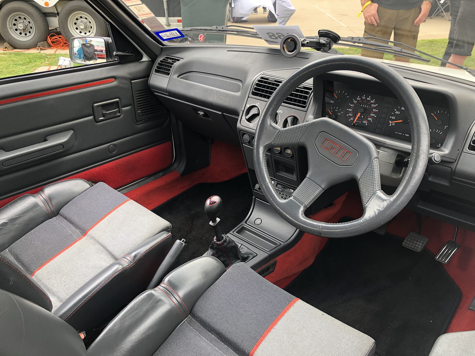 Habitacle d’une Peugeot 205 GTI avec sièges et moquette caractéristiques