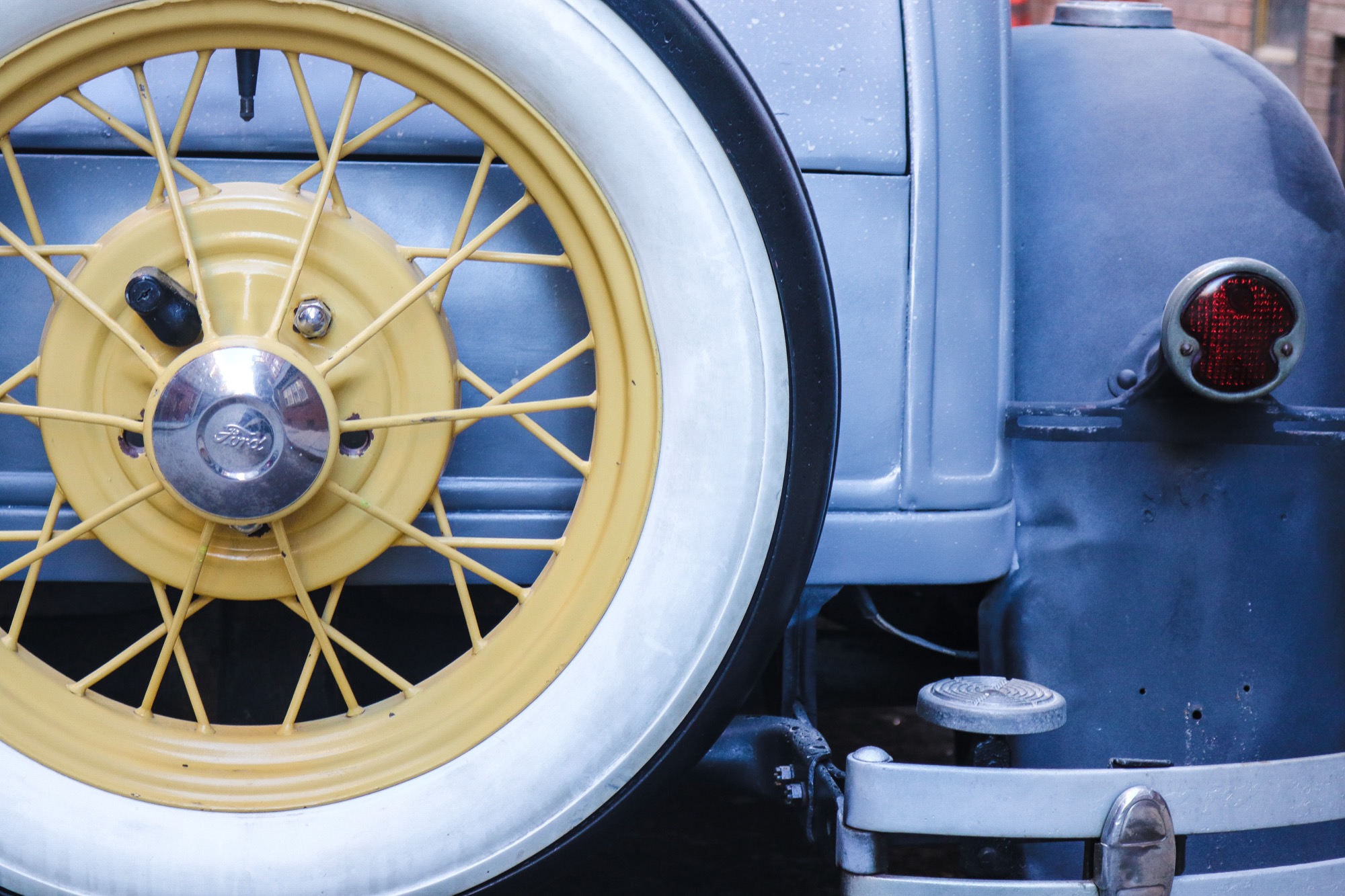 Roue à rayons et pneu à flanc blanc d’une voiture ancienne