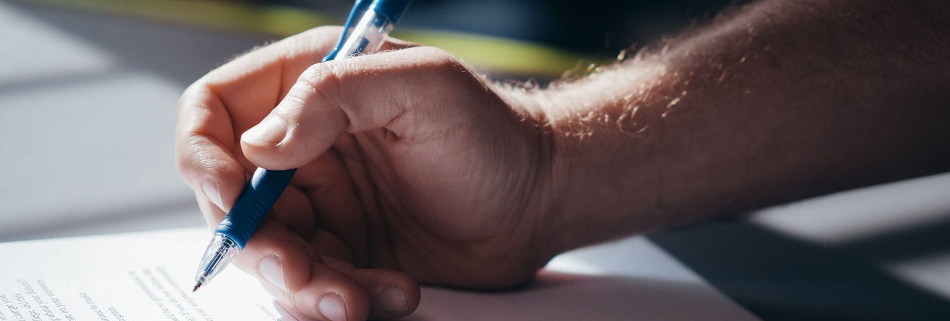 Main signant un document pour préparer la transmission d’une voiture de collection