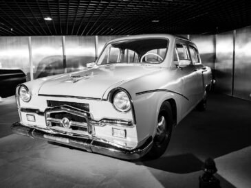 Voiture ancienne noire et blanche exposée dans un showroom automobile