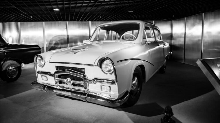 Voiture ancienne noire et blanche exposée dans un showroom automobile